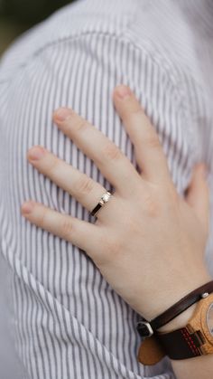 a close up of a person's hand with a watch on their wrist and ring