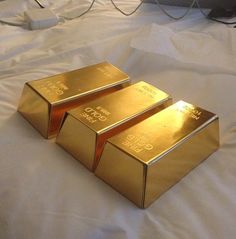 three gold bars sitting on top of a bed