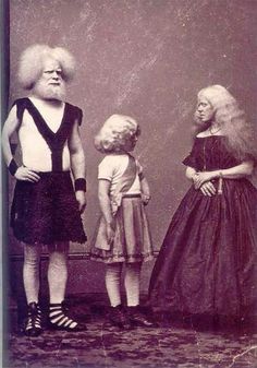 an old photo of three children standing in front of a man with long blonde hair