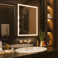 a bathroom with a sink, mirror and lights on the wall above it's counter