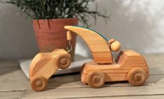 a wooden toy car sitting next to a potted plant