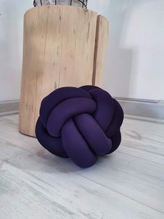 a purple knot sitting on top of a wooden block