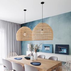 a dining room with blue walls and wicker chandelier hanging from the ceiling