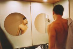 a man standing in front of a bathroom mirror