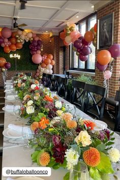 a long table is set with flowers and balloons