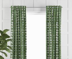 a window with green curtains and a potted plant