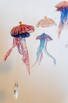 three jelly fish hanging from strings in the air