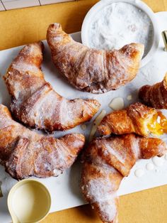 croissants and other pastries on a plate with dipping sauce next to them