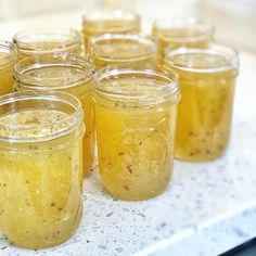 several jars filled with food sitting on top of a white counter next to each other