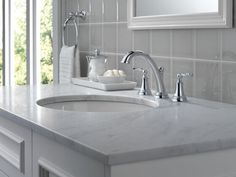 a bathroom sink with two faucets and soap dispenser