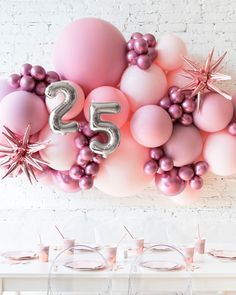 balloons and stars are arranged on the wall for a 25th birthday party with pink and silver decorations