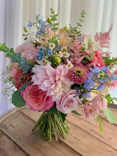 a bouquet of flowers sitting on top of a wooden table