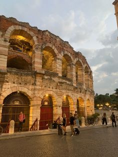 people are walking around in front of an old building