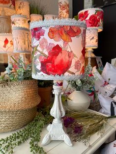 a table topped with lots of different types of lamps and flowers on top of it