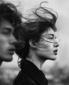 two people with hair blowing in the wind