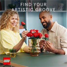 a man and woman sitting at a table with vases of flowers in front of them