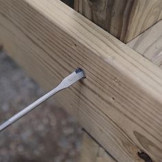 a close up of a piece of wood with a screwdriver stuck in it