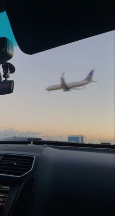 an airplane is flying in the sky over some buildings and cars with dashboard lights on