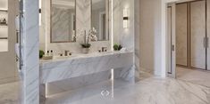 a marble bathroom with double sinks and mirrors