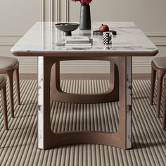 a marble table with chairs around it and flowers in vases on the table top