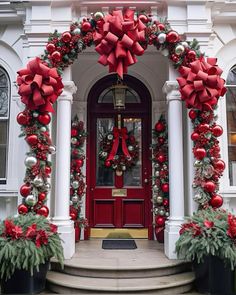 a red front door decorated with christmas decorations