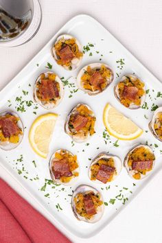 a white plate topped with oysters covered in bacon