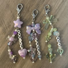 three key chains with charms attached to them sitting on a table next to each other