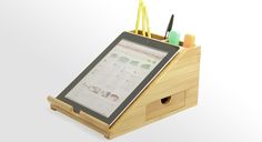 an ipad and pen holder made out of bamboo with writing utensils in it