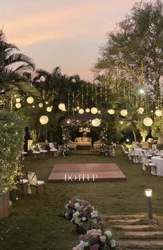 an outdoor wedding setup with lights and flowers