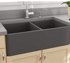 an image of a kitchen sink in the middle of a counter top with potted plants