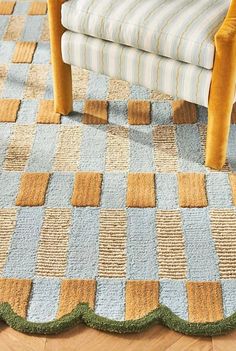 a chair sitting on top of a wooden floor next to a blue and yellow rug