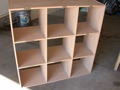 a book shelf with several shelves on it in a garage next to a table and motorcycle