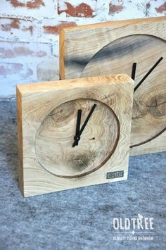 two wooden clocks sitting side by side on the floor