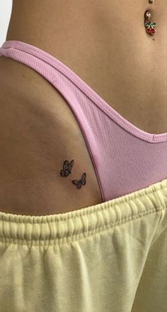 a woman's stomach with two butterflies on her left side and the lower part of her right arm