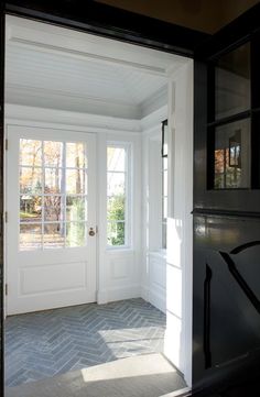 an empty entryway with white doors and brick flooring in front of the door