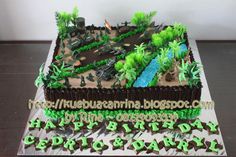 a cake that is decorated with green and brown icing on top of a table