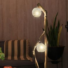 two lights that are next to each other on a table in front of a potted plant