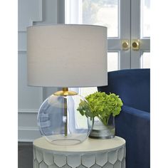 a lamp that is on top of a table with a potted plant in it