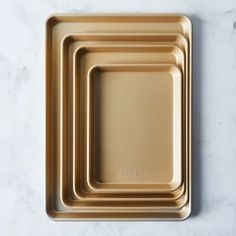 three gold trays sitting on top of a marble counter