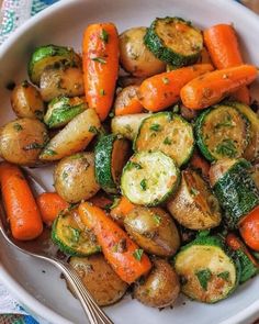 a white bowl filled with carrots, zucchini and brussel sprouts