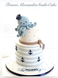 a three tiered cake decorated with an octopus and sailor's knot on top