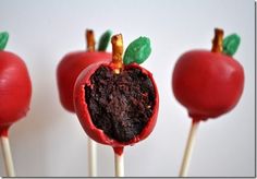 three red cake pops with green leaves on them