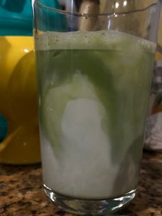 a glass filled with liquid sitting on top of a counter