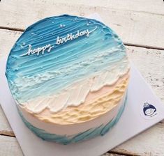 a blue and white birthday cake with the words happy birthday written on it's frosting