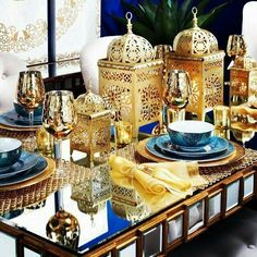 the table is set with gold and blue dishes