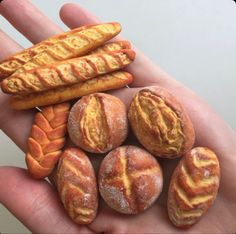 a person's hand holding several different types of breads