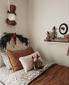 a bed with two teddy bears on top of it and christmas decorations hanging from the headboard