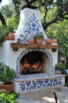 an outdoor fireplace with blue and white tiles