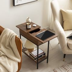 a laptop computer sitting on top of a wooden table next to a white couch and chair