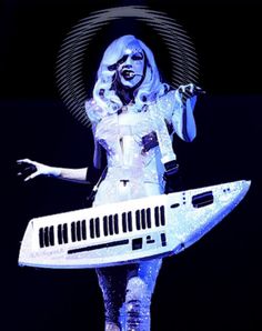 the woman is dressed in white and holding a musical keyboard as she stands on stage